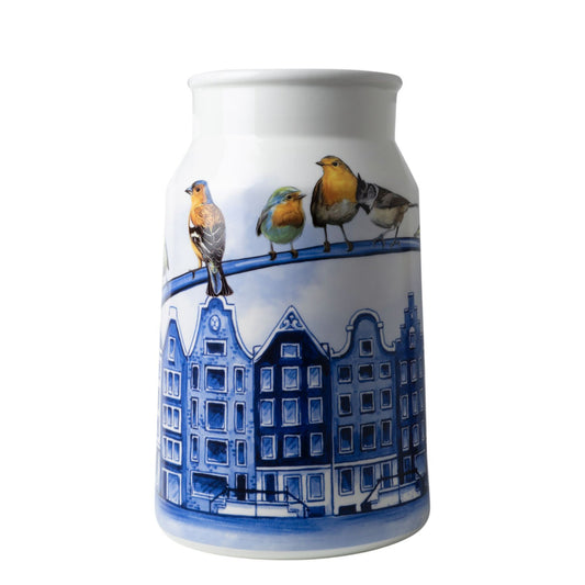 Breng de iconische schoonheid van de Amsterdamse grachten naar je huis met deze prachtige vaas in de vorm van een melkbus, gedecoreerd met schilderachtige grachtenpanden. Een uniek stuk dat de charme van de stad in huis haalt.